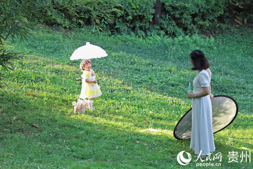 市民在阿哈湖公園內拍寫真。人民網 顧蘭云攝