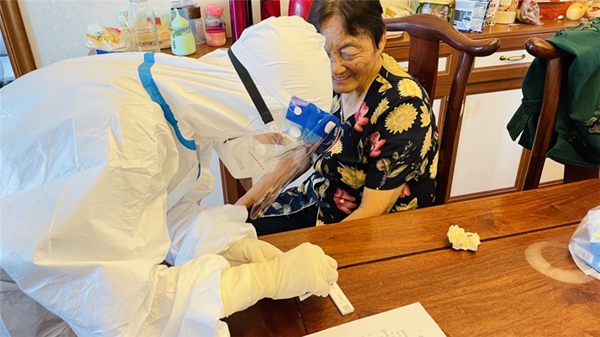 2 對于不會操作小程序及不會抗原自測的老年人，小區志愿者上門幫助他們完成檢測。受訪者供圖