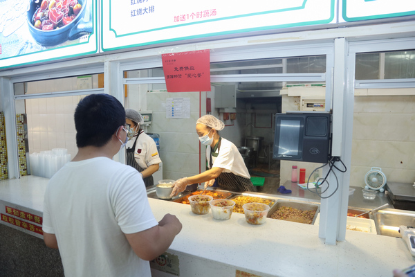 貴州醫科大學學生在“貴醫愛心餐”供應窗口取餐。