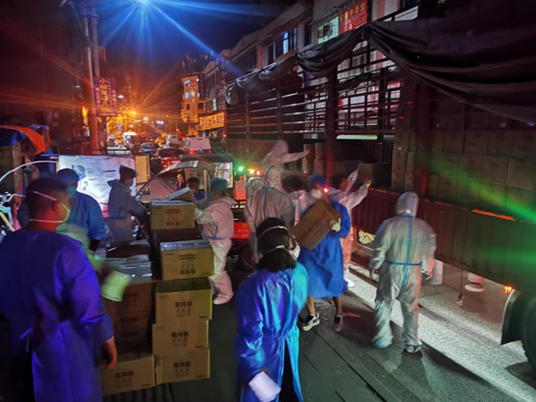 市、區商務部門下沉干部與社區干部、志愿者連夜配送生活物資。畢節市商務局供圖