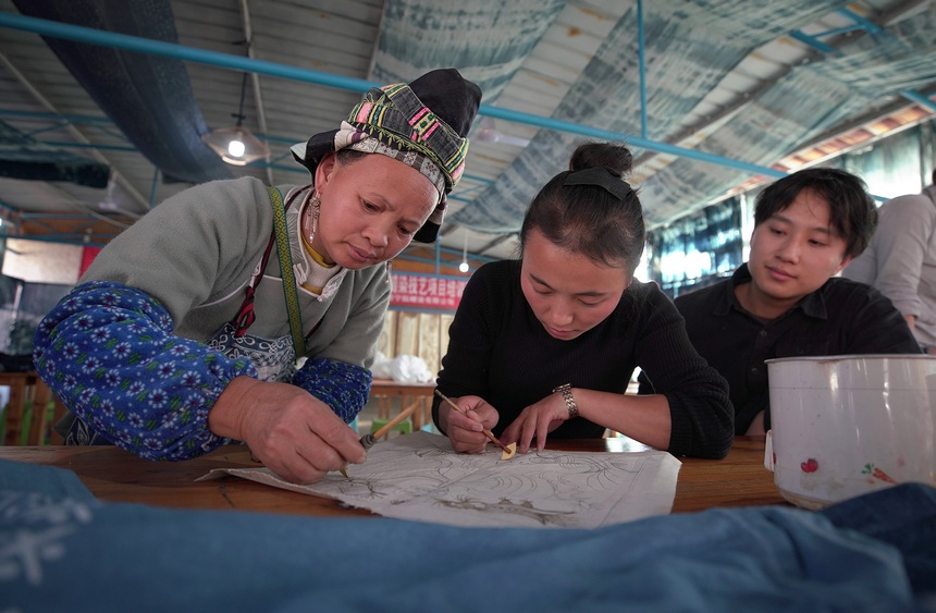 11月10日，學員向蠟染畫娘學習蠟畫繪制技藝。