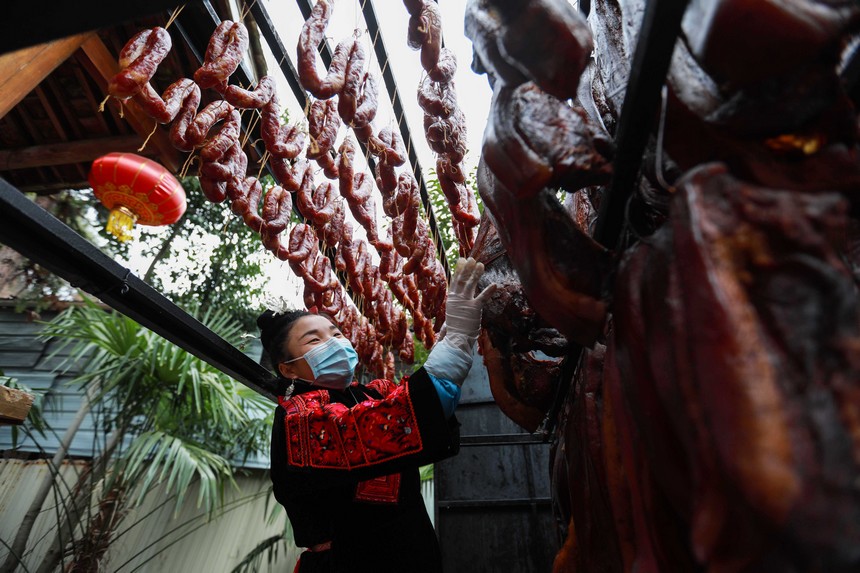 2023年1月2日，苗族群眾在查看臘肉熏制情況。