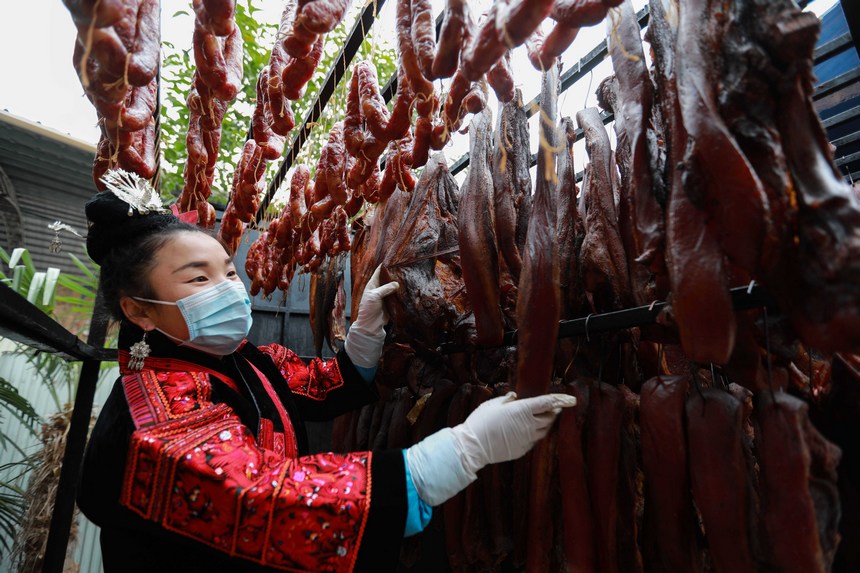 2023年1月2日，苗族群眾在查看臘肉熏制情況。