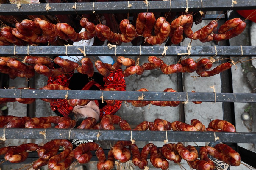 2023年1月2日，苗族群眾在查看臘肉熏制情況。