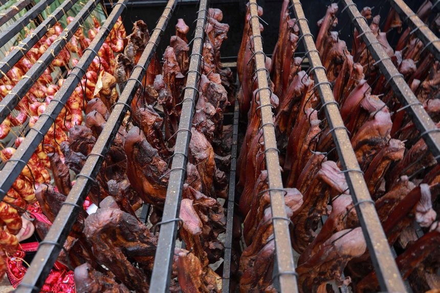 2023年1月2日，苗族群眾在查看臘肉熏制情況。