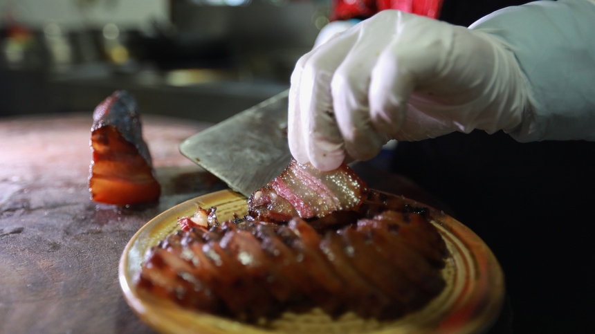 2023年1月2日，苗族群眾在切成品的臘肉。