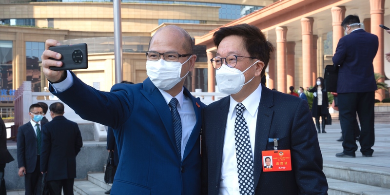 政協委員站在會議中心門口合影留念。人民網 陽茜攝