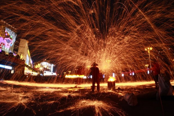 表演者用鐵鍬將高溫鐵水拋向空中。蘇陽攝