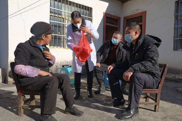 2023年1月13日，威寧自治縣么站鎮新飛社區村醫李仁英（左二）為村民夏秀支老人送藥。