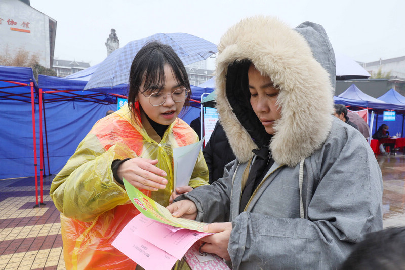 志愿者向求職者介紹崗位信息。