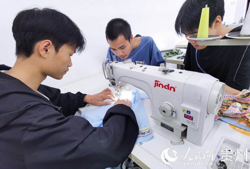 民族服飾實操教室內，同學們正在做衣服。人民網 王秀芳攝