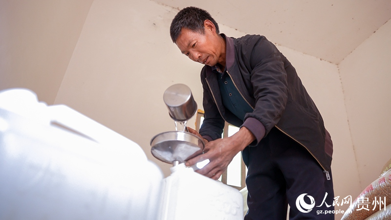 3 海元村村民冷統乖向附近村民出售他烤制的土酒。人民網記者 涂敏 攝