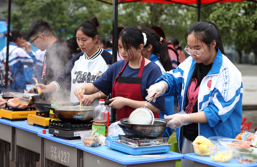 高三年級學生在“校園美食節”上烹飪美食。黃曉海攝