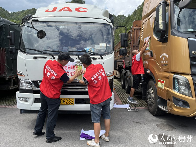 2.貨車司機在車身上張貼紅渡村宣傳海報。人民網 李麗萍攝