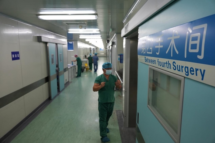 2方鴻完成手消毒，走進手術室準備為患者實施手術。