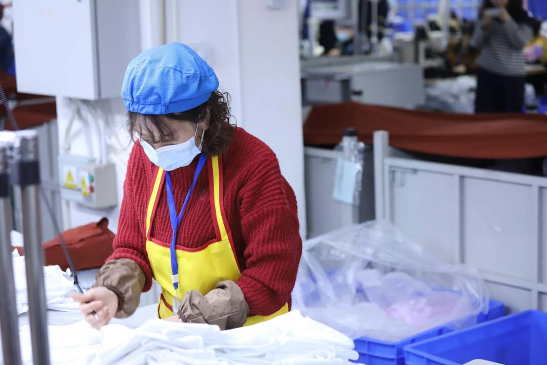  圖為工人對衣物進行質檢。