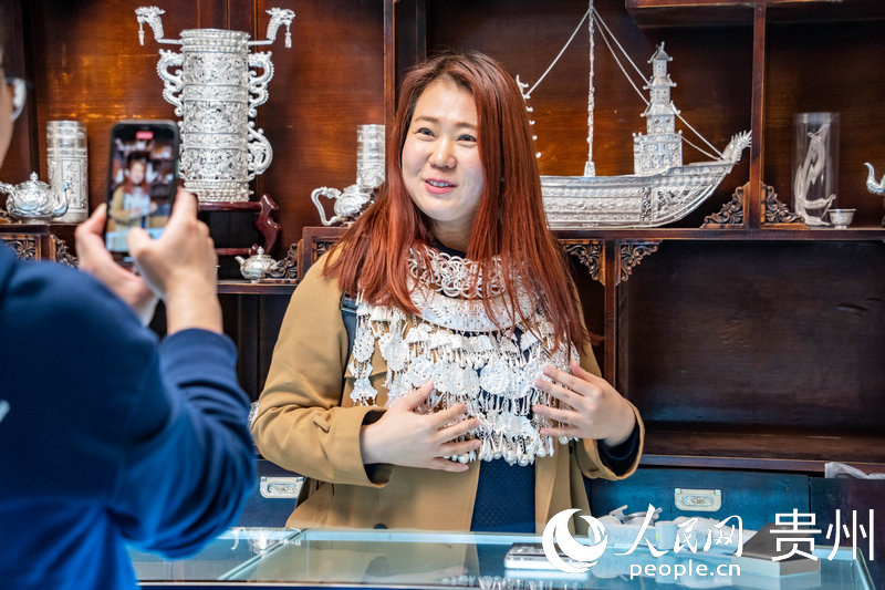 歐亞國家記者試戴苗族銀飾。人民網 陽茜攝
