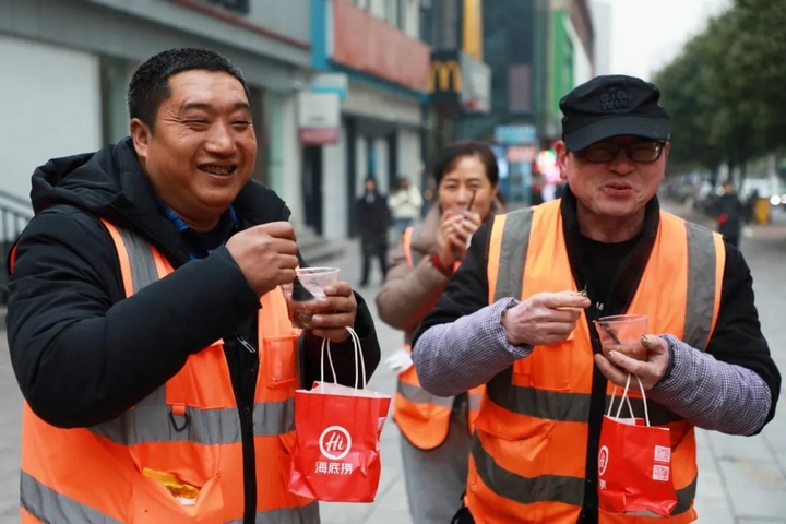 1、環衛工人們喝著愛心粥，臉上洋溢著暖心的笑容。