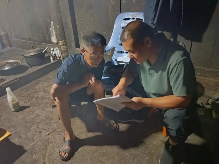 李云（右）進村入戶宣傳政策。貴旅集團供圖