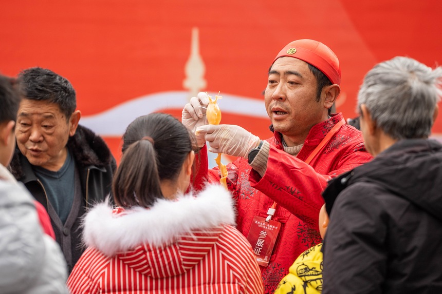 市民正在觀看“吹糖人”技藝展示。羅大富攝