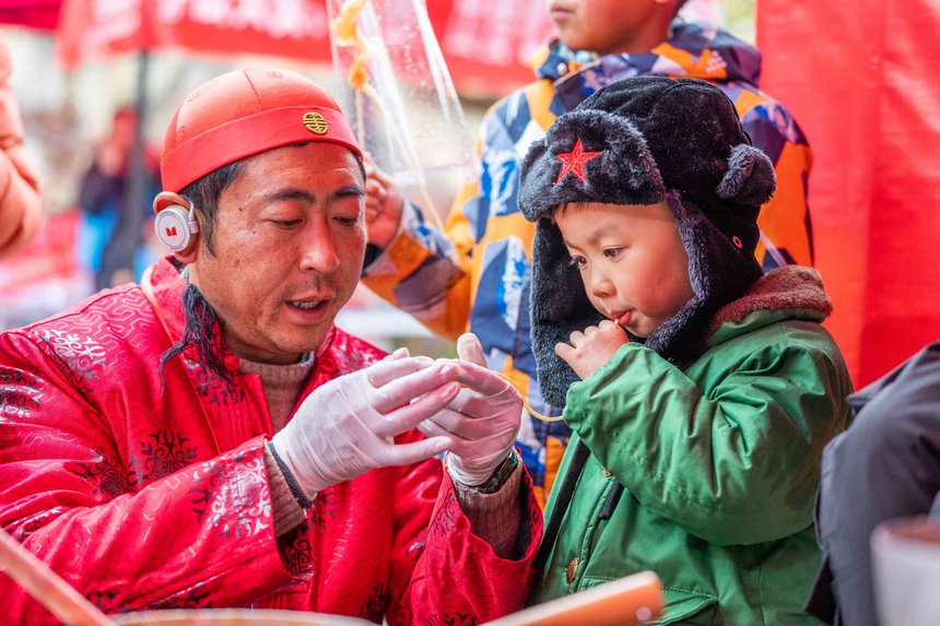 小朋友現場體驗“吹糖人”技藝。羅大富攝