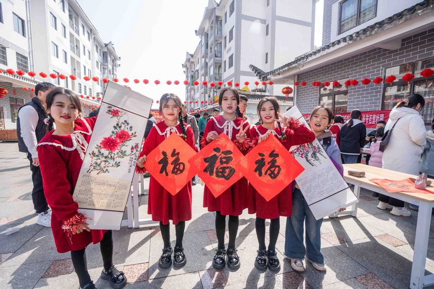 小朋友們展示現場領取的春節字畫。羅大富攝