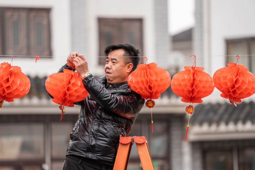 社區群眾在懸掛紅燈籠。羅大富攝