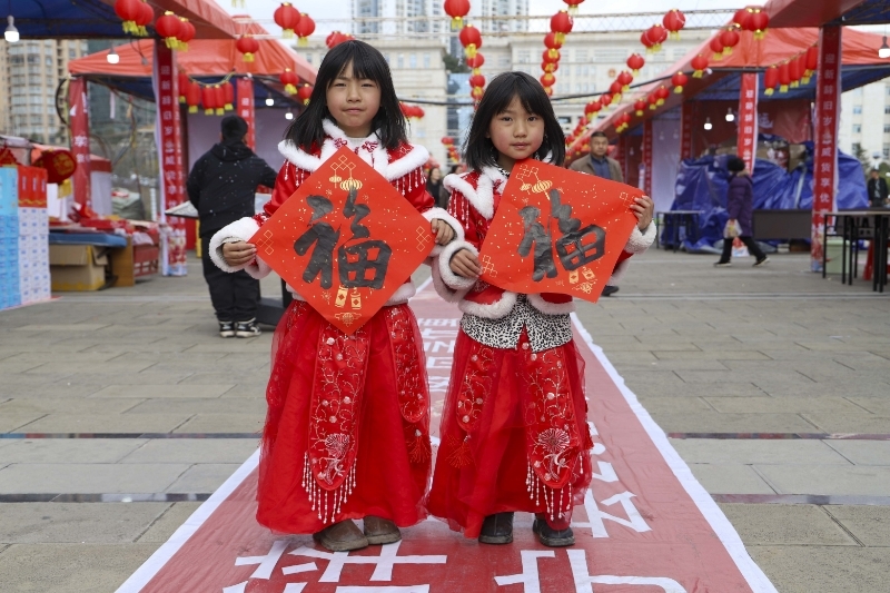小朋友舉著新買的福字拍照。管慶巍攝