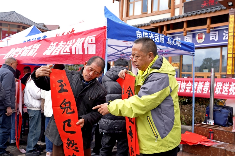 活動現場，電信公司工作人員給市民讀春聯。楊英攝