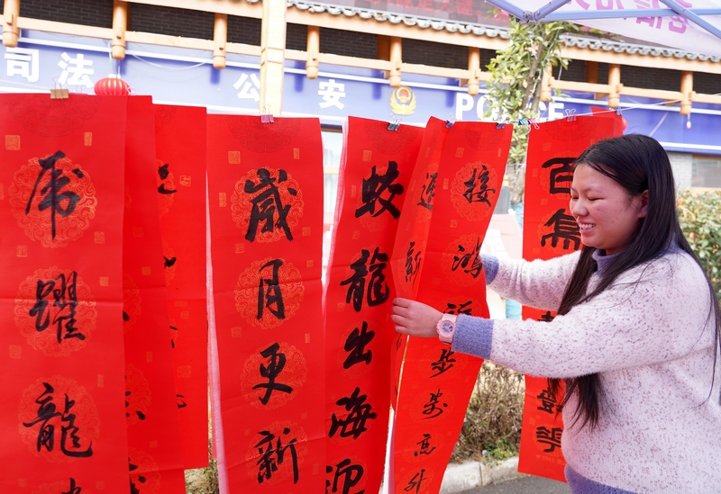 市民在挑選剛剛寫好的春聯。楊英攝