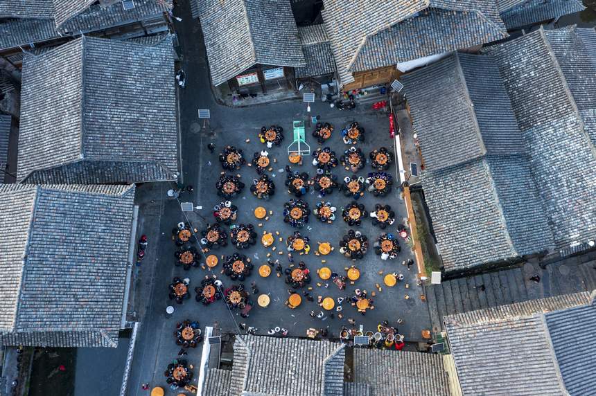 貴州省從江縣往洞鎮增沖村，當地侗族同胞與來自該縣停洞鎮架里村的苗族同胞在鼓樓旁的院壩吃晚飯（無人機照片）。