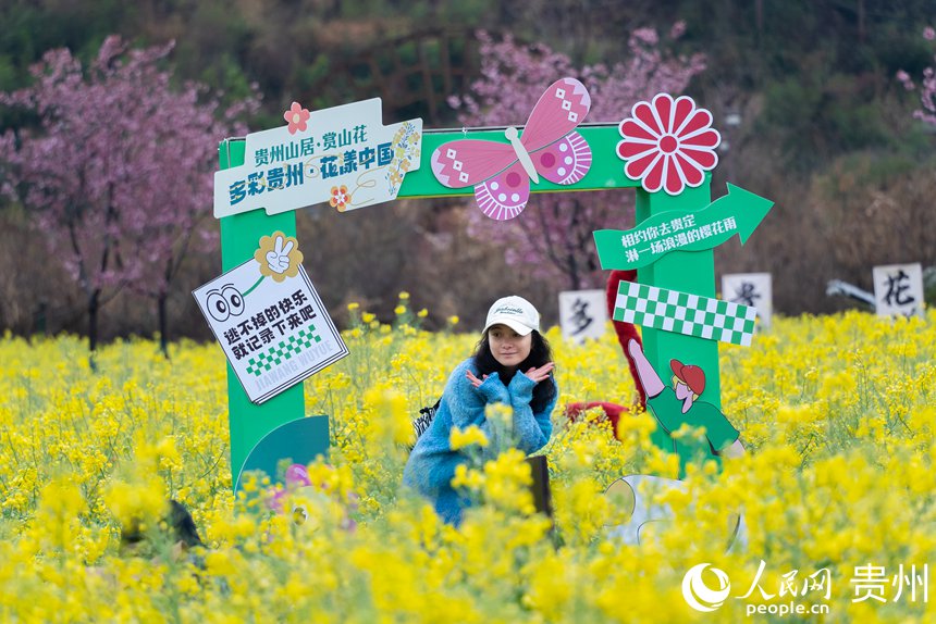 游客在油菜花中打卡拍照。人民網記者 涂敏攝