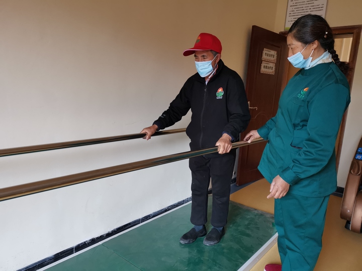 護理工指導老人復健。