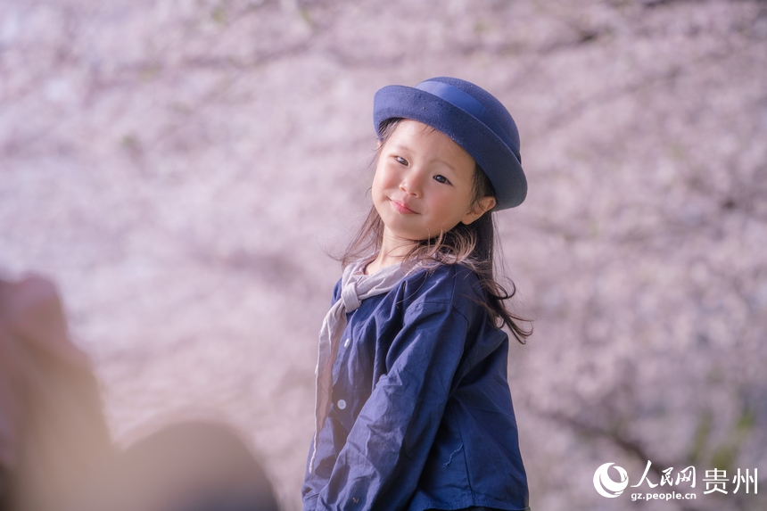 小朋友在櫻花樹下拍照。人民網 陽茜攝