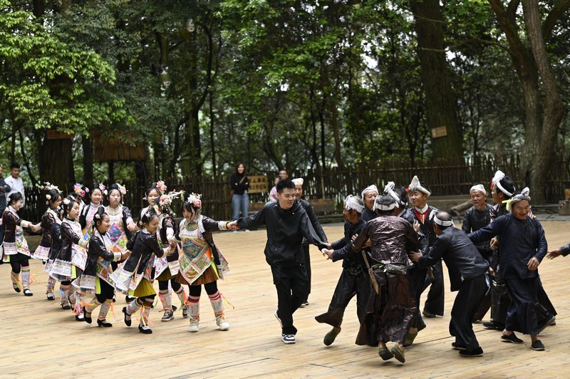 2024年5月1日，一名游客在貴州省從江縣丙妹鎮岜沙苗寨景區參與婚俗表演。