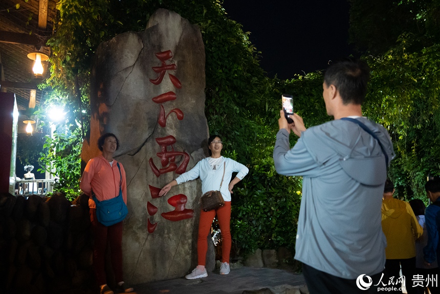 游客在西江苗寨內打卡拍照。人民網記者 涂敏攝