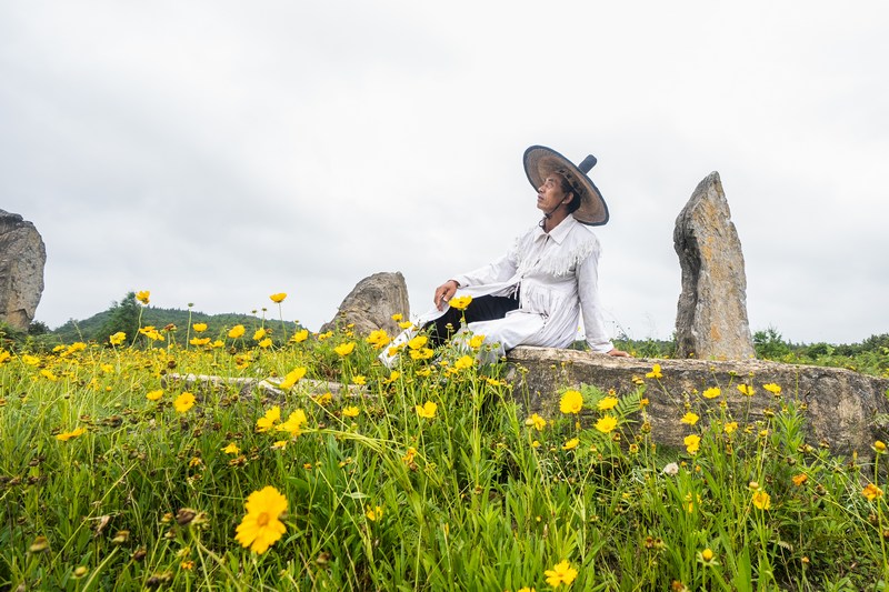 2024年7月5日，在貴州省畢節市百里杜鵑管理區方家坪景區，黃承龍坐在巨石陣里休息。 