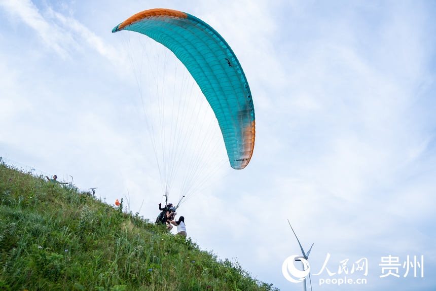 游客在玉簪花海中體驗滑翔傘。人民網記者 涂敏攝