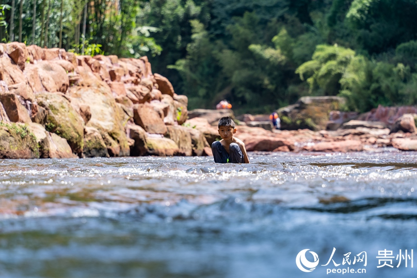 在瑪瑙灘內戲水的小朋友。人民網記者 涂敏攝