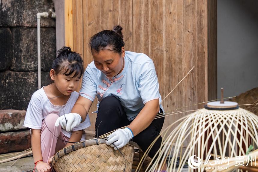 小朋友跟著媽媽學習竹編技藝。人民網記者 涂敏攝