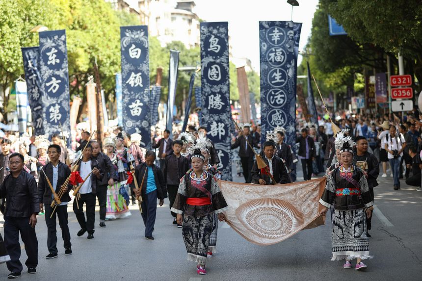 7月21日，貴州省丹寨縣身著傳統盛裝服飾的群眾，在展示國家級非遺項目苗族蠟染作品。