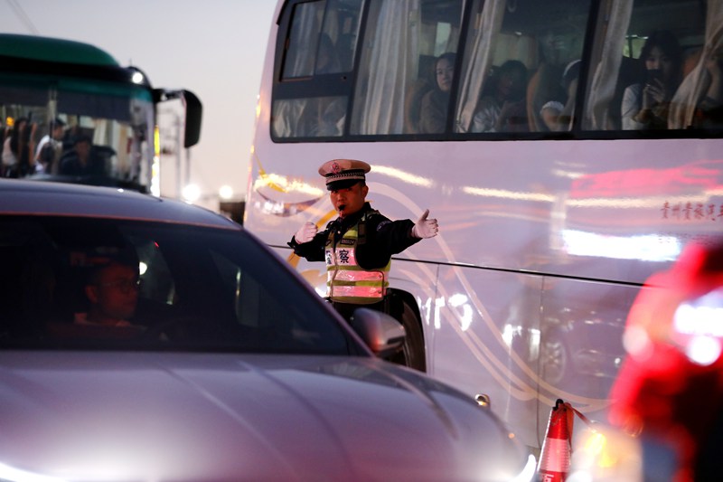 10月4日，雷山縣公安局交警大隊輔警在西江千戶苗寨景區營上路口疏導交通。