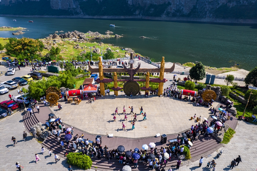 貴州省黔西市烏江源百里畫廊化屋景區，游客觀賞當地苗族村民表演原生態歌舞（無人機照片）。