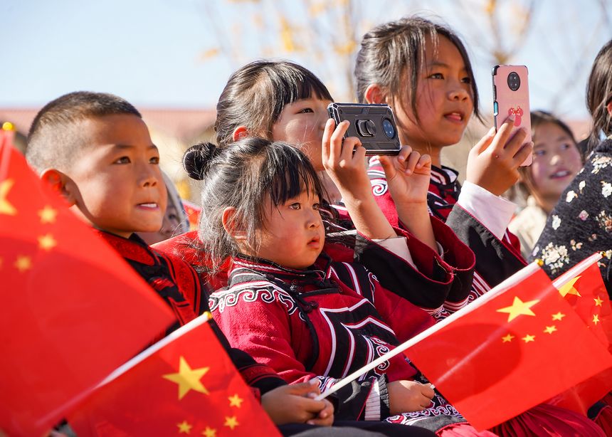 慰問演出現場，身著民族服飾的觀眾用手機記錄精彩瞬間。趙慶能攝