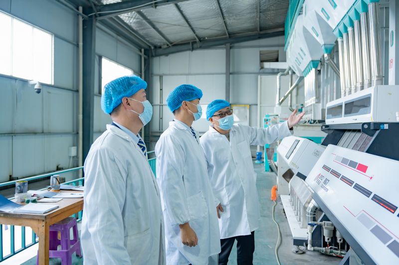 郵儲銀行惠水縣支行工作人員實地了解黑糯米產業自動化生產情況。郵儲銀行貴州省分行供圖