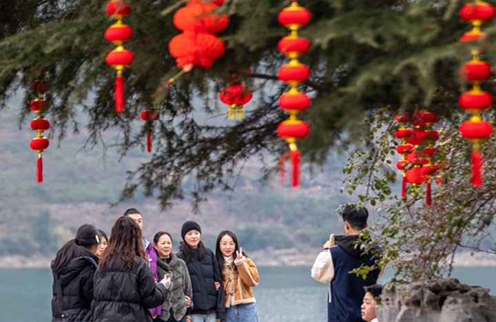 游客在碼頭廣場拍照。