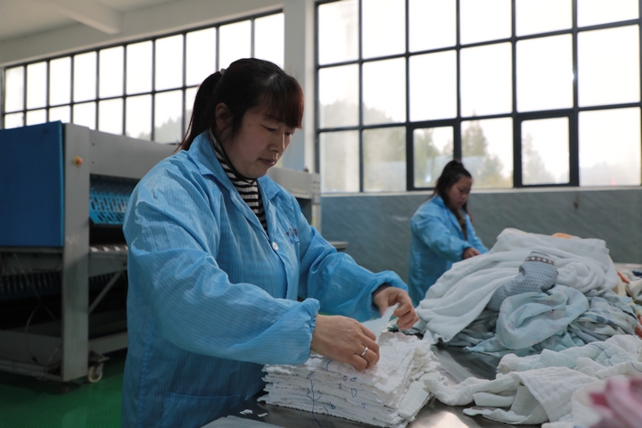 圖為在石阡縣大沙壩鄉付家坪村和星洗滌工坊，工人們正在折疊干凈布草。楊文美攝 (3).JPG