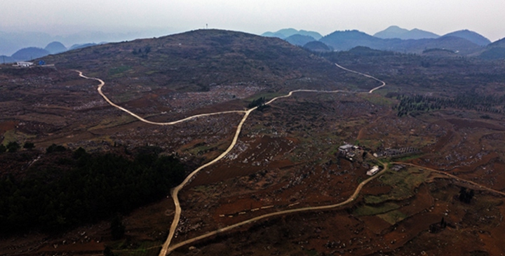 航拍貴州省黔西市鐵石苗族彝族鄉鐵盔山村的機耕道與村莊、山巒、田地構成一幅生機盎然的田園畫卷。  熊軍萬攝