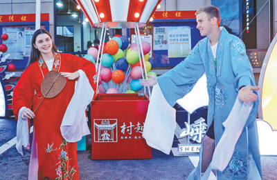 馬克西姆（右）和葉卡捷琳娜在“村越”現場體驗越劇服裝。