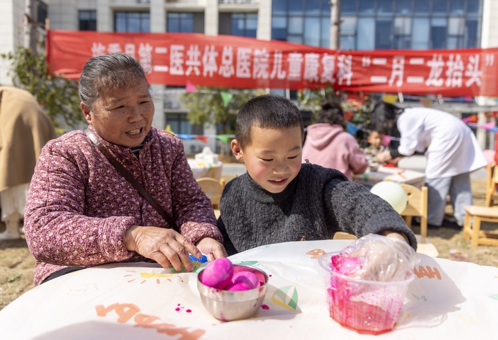 2025年2月28日，貴州省黔東南苗族侗族自治州施秉縣第二醫共體總醫院兒童康復科，家長在指導孩子染紅蛋。（磨桂賓 攝） (1).jpg